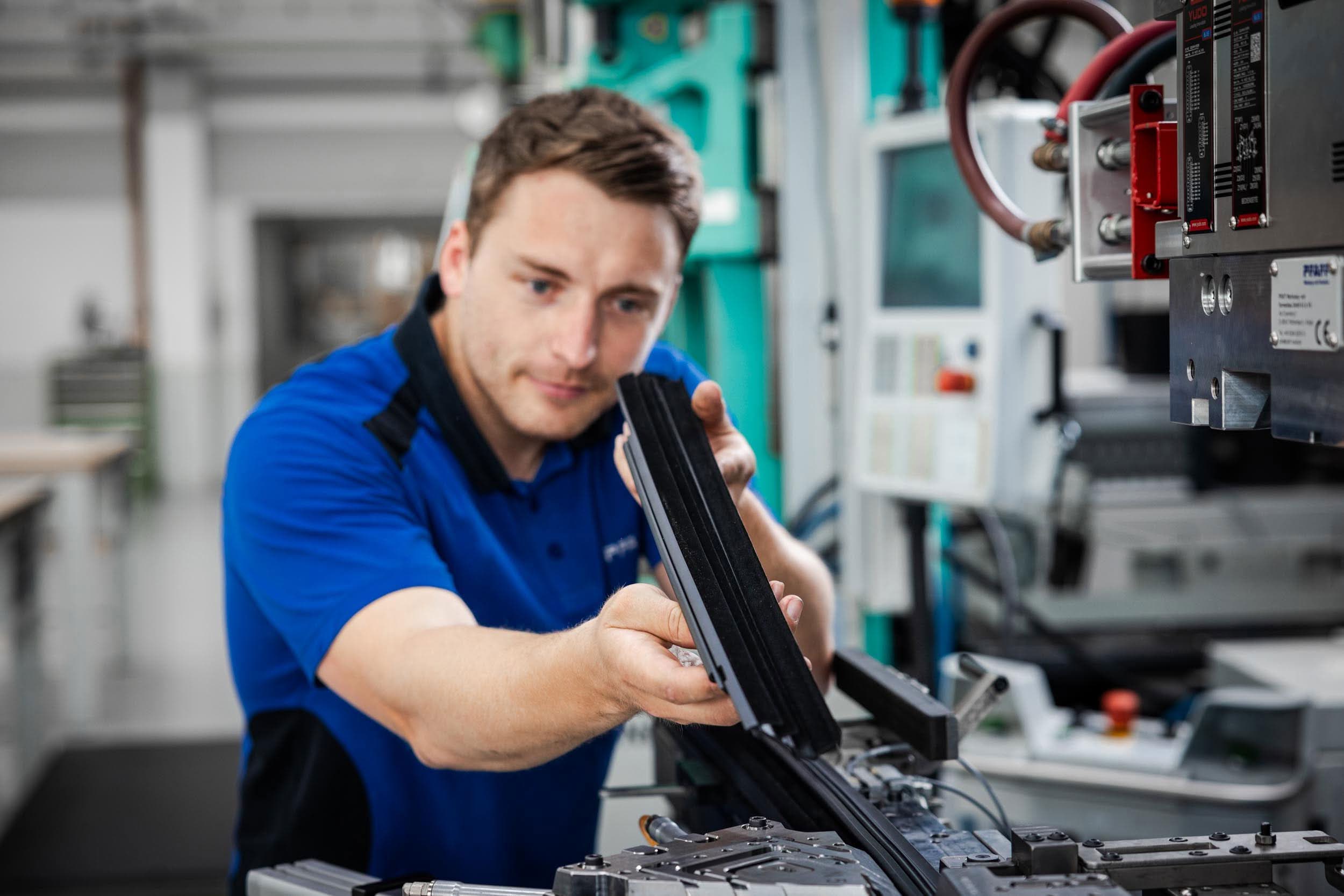 Technician checking a molded sealing profile at the production system