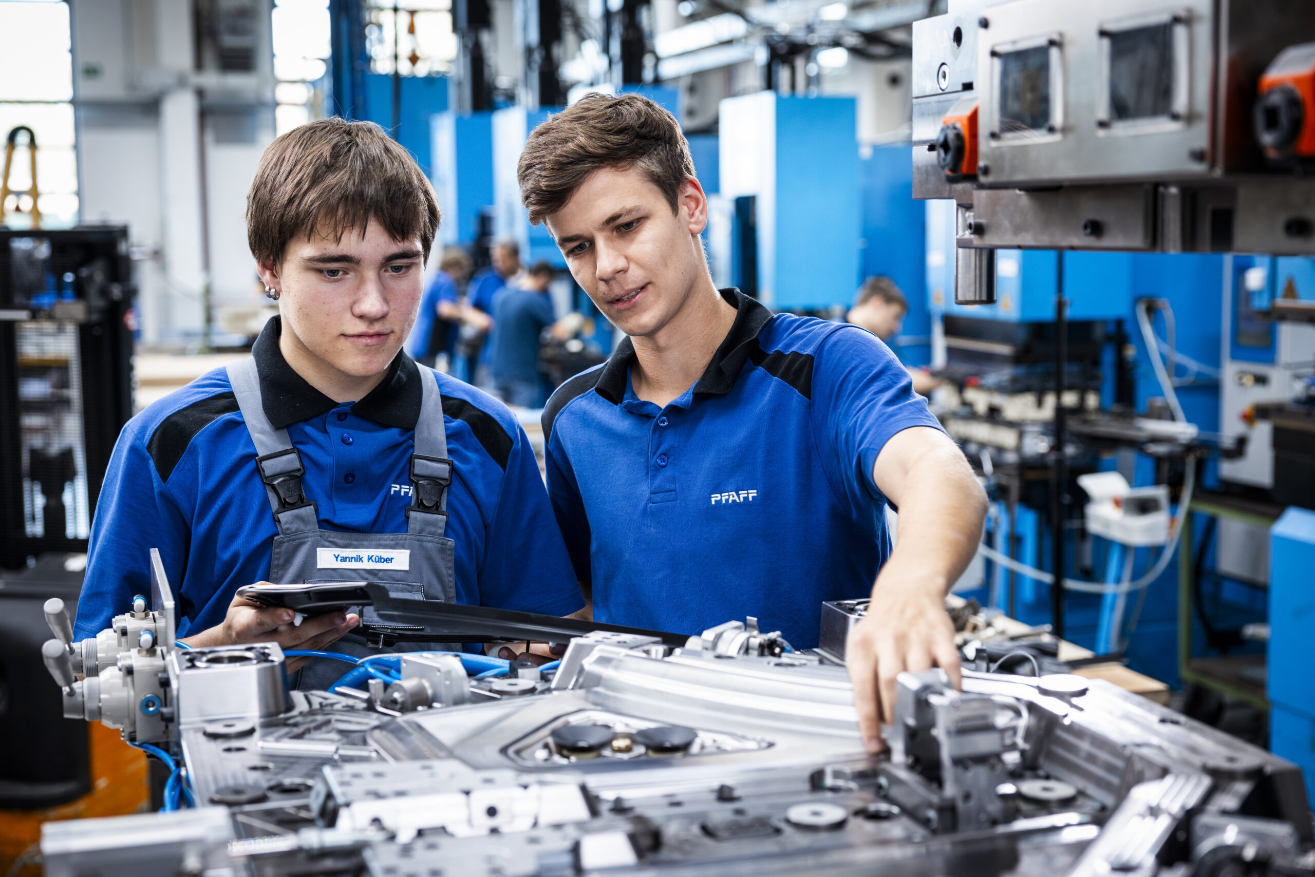 Two apprentices assemble components on a PFAFF mold and toolmaking system