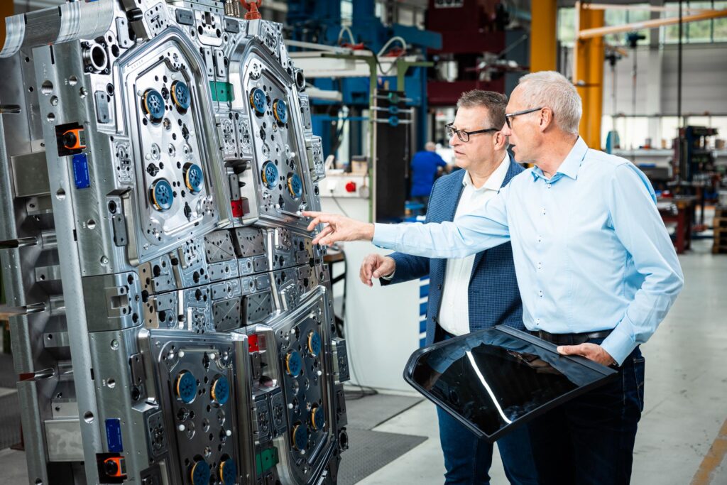 Zwei Ingenieure begutachten Industriemaschinen und Produktionsanlagen in der Fabrikhalle.