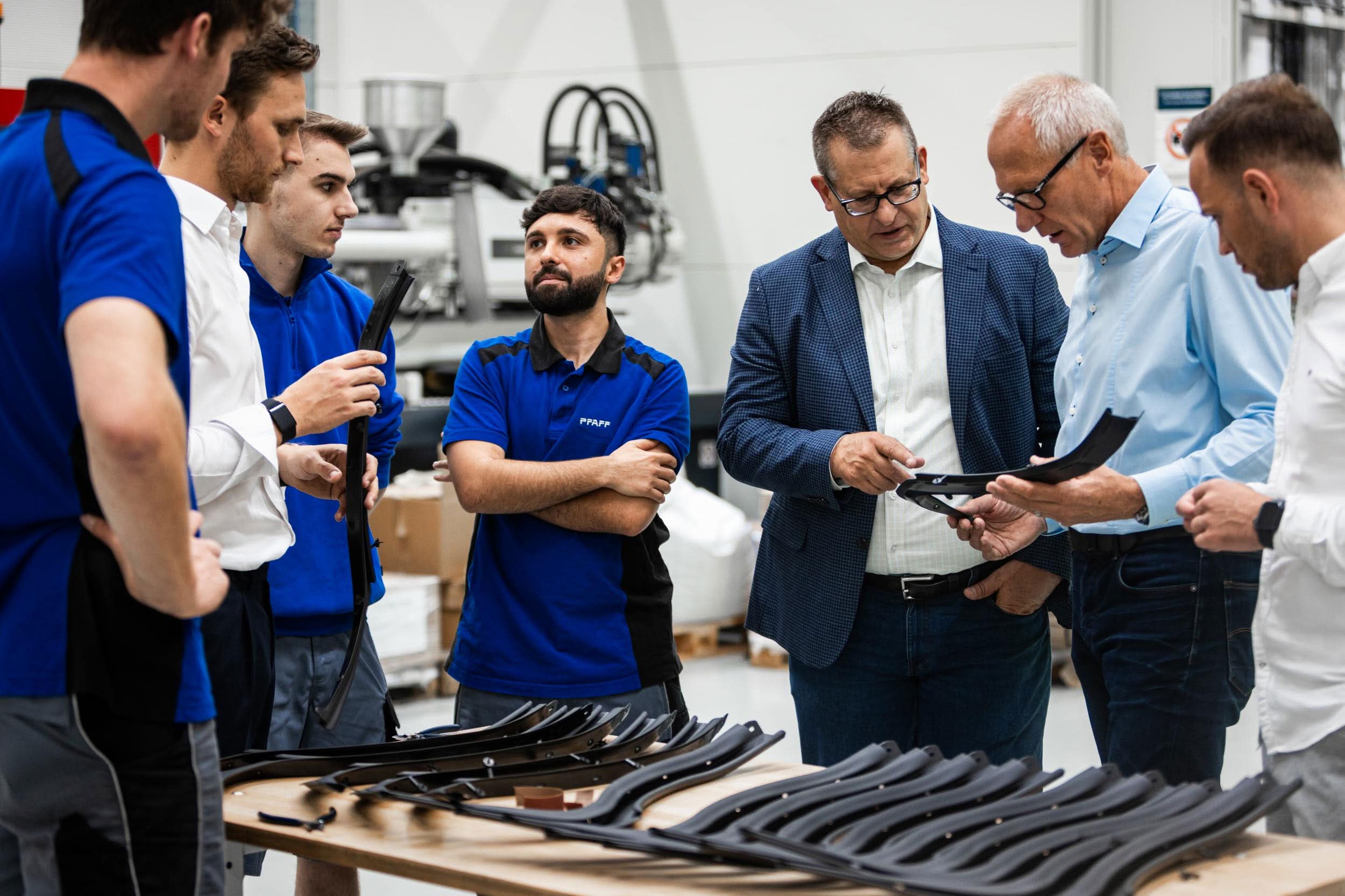 PFAFF-Team und Kunden inspizieren extrudierte Gummidichtungsprofile in der Produktionshalle
