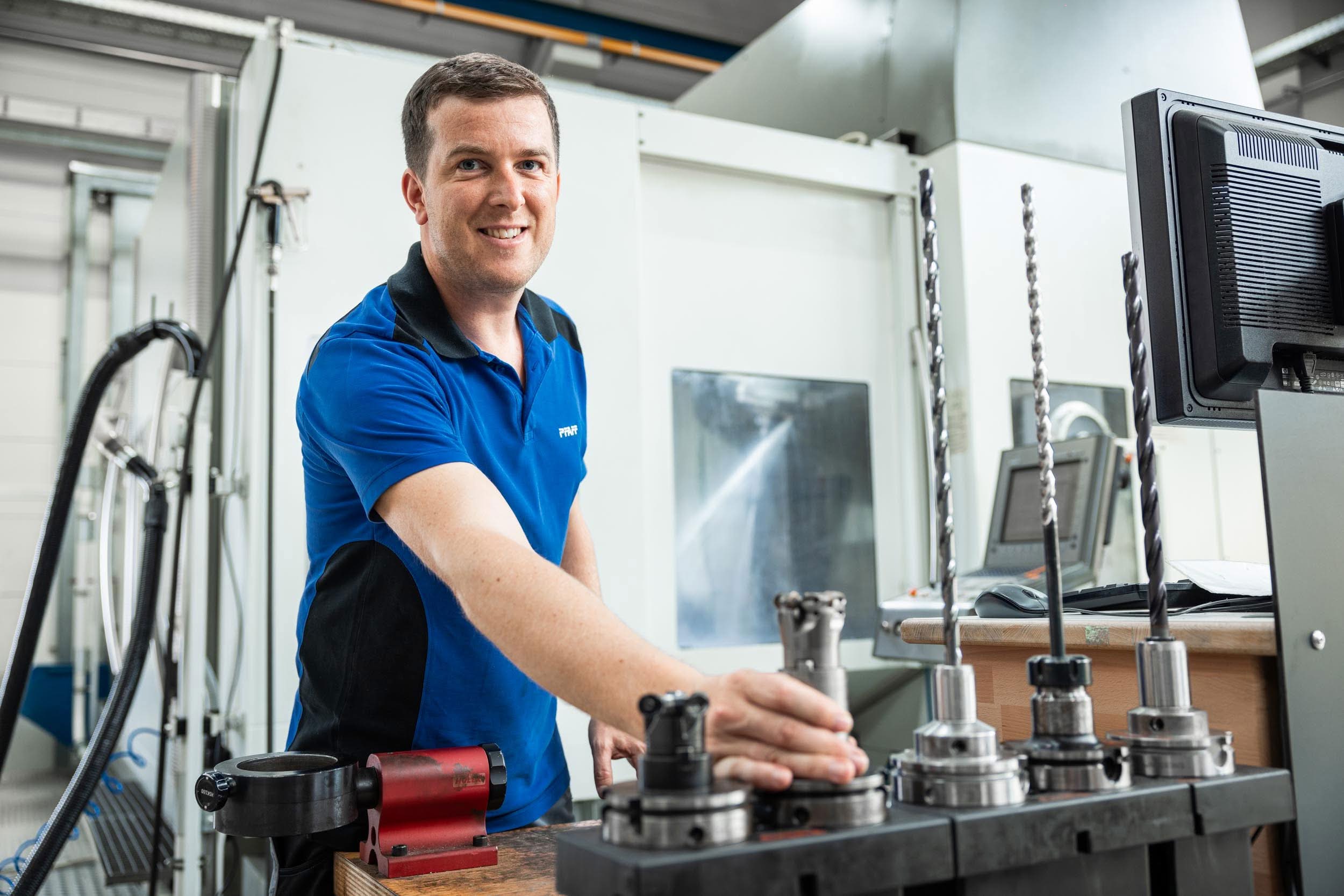 Zerspanungsmechaniker bereitet Werkzeughalter an einem CNC-Bearbeitungszentrum vor