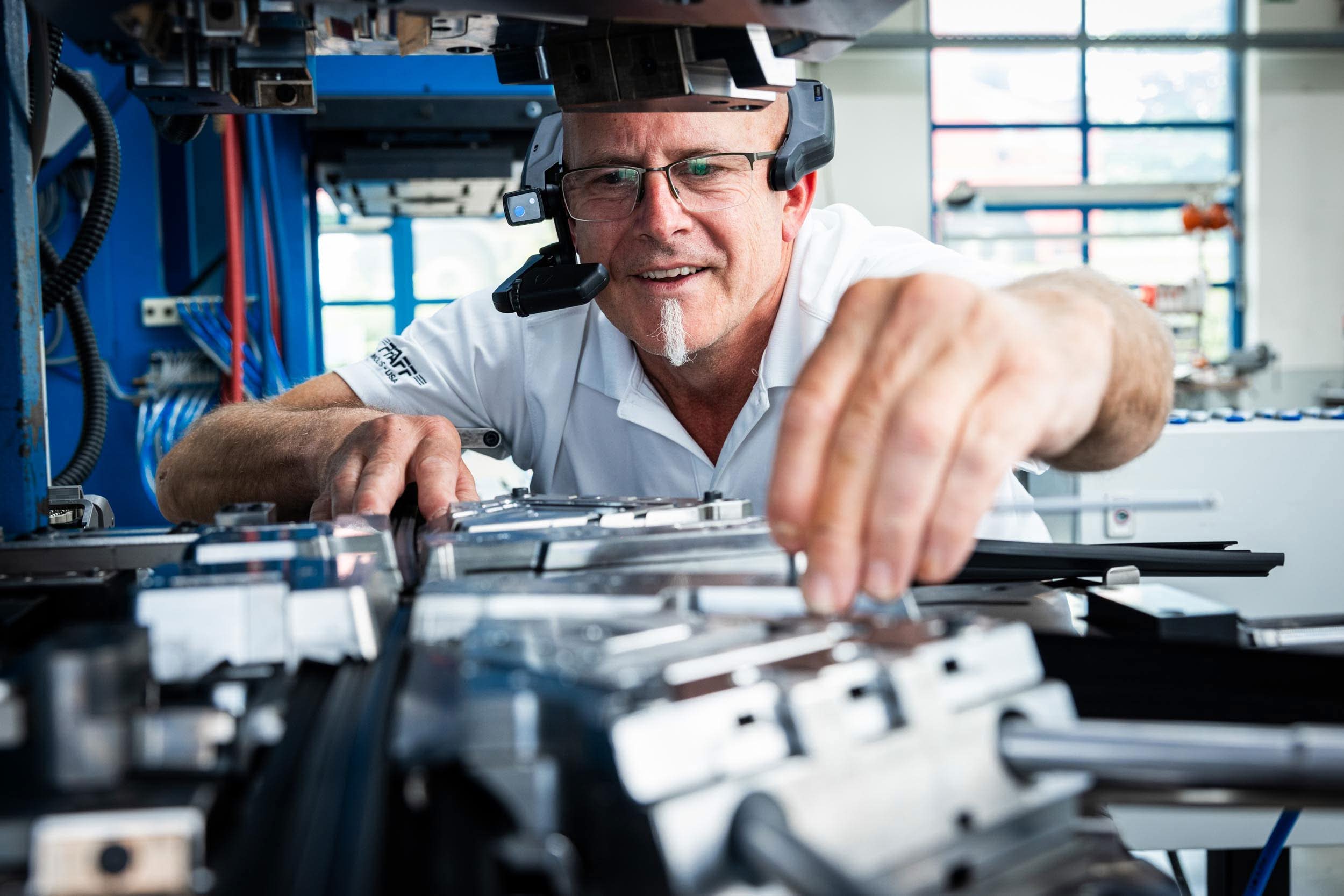 Techniker justiert Komponenten eines automatisierten Produktionssystems