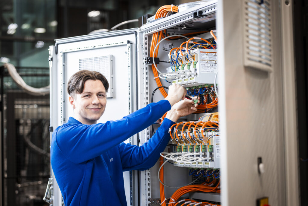 Apprentice wiring a control cabinet