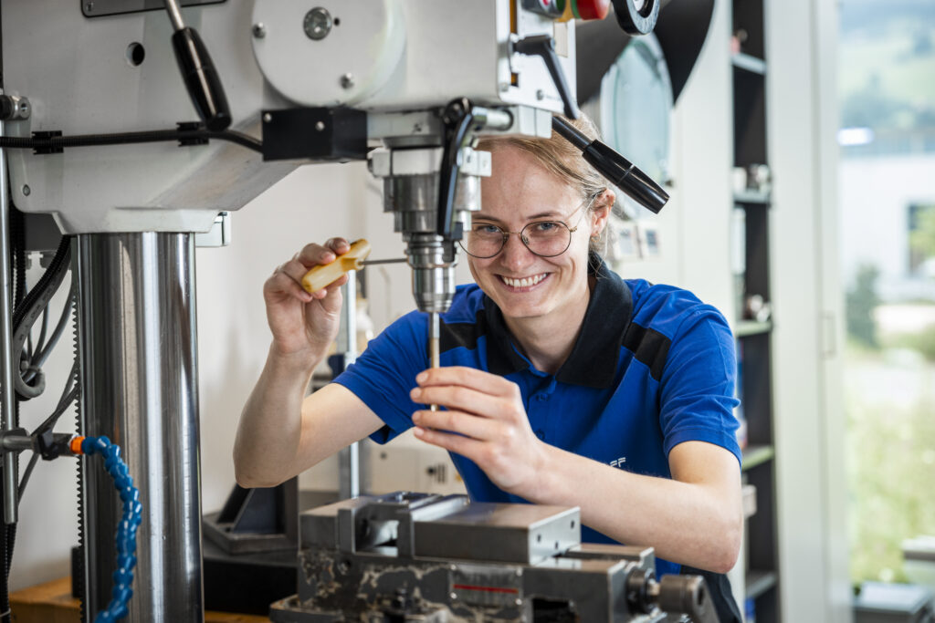 Apprentice laughing while working on a drilling machine